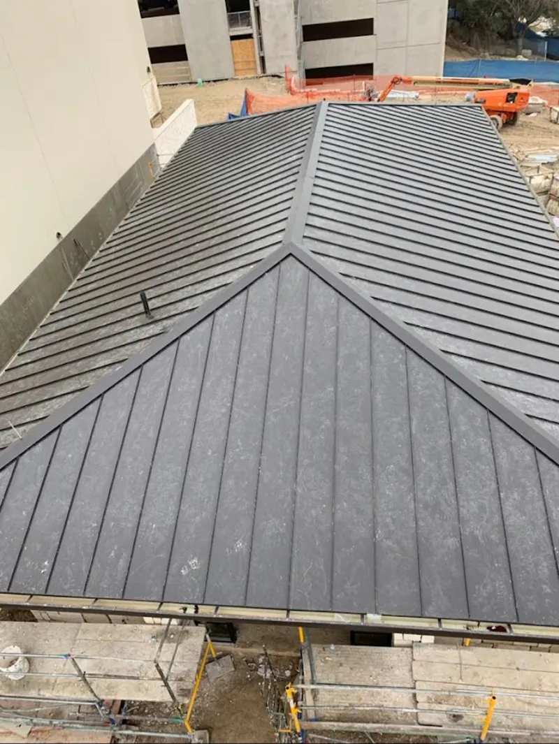 Commercial metal roof construction with crane equipment in St. Ann